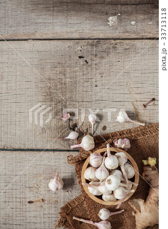 Garlic in bowls on wooden floor. 33713118