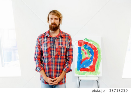 Young male artist standing with a picture 33713259