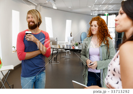 Young people standing in a gallery and contemplating artwork 33713292