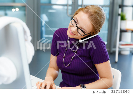 Business woman in office holding mobile phone 33713846
