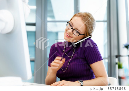 Business woman in office holding mobile phone Business woman in office holding mobile phone 33713848