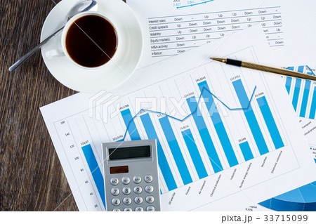 Financial charts and graphs on the table 33715099