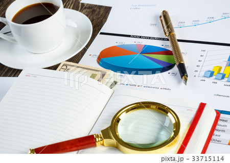 Financial charts and graphs on the table 33715114