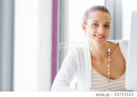 Attractive office worker sitting at desk 33715523