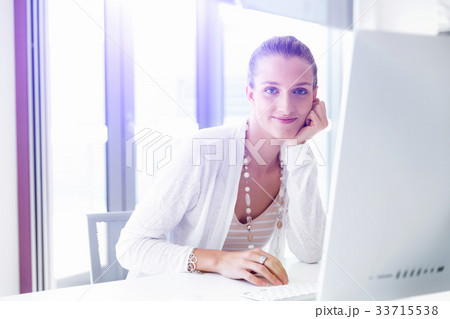 Attractive office worker sitting at desk 33715538