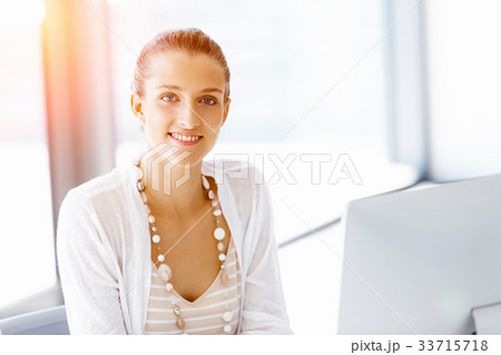 Attractive office worker sitting at desk 33715718