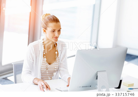 Attractive office worker sitting at desk Attractive office worker sitting at desk 33715746