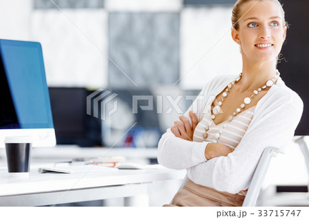 Attractive office worker sitting at desk Attractive office worker sitting at desk 33715747