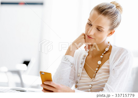 Attractive office worker sitting at desk 33715779