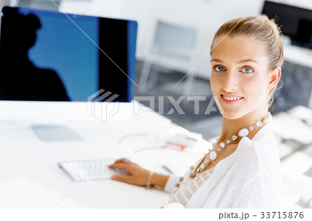 Attractive office worker sitting at desk 33715876