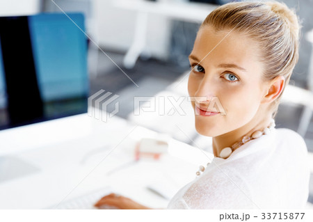 Attractive office worker sitting at desk 33715877