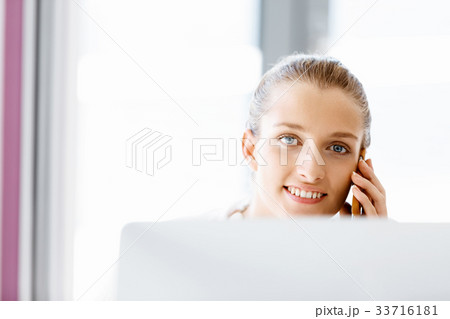 Attractive office worker sitting at desk 33716181