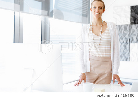 Attractive office worker standing next to window Attractive office worker standing next to window 33716480