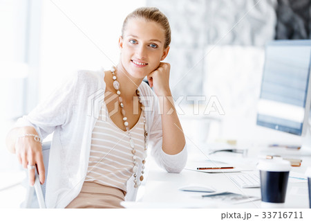 Attractive office worker sitting at desk 33716711
