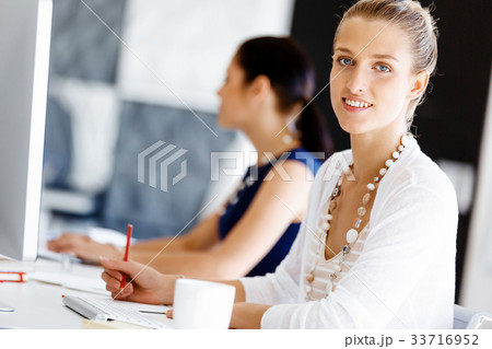 Attractive office worker sitting at desk 33716952