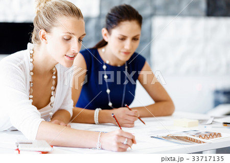 Two female colleagues in office Two female colleagues in office 33717135