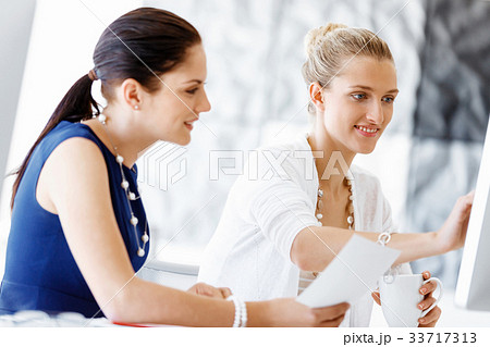 Two female colleagues in office Two female colleagues in office 33717313