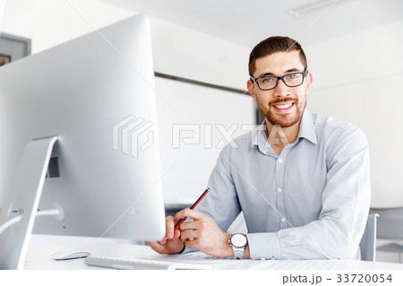 Male office worker sitting at desk Male office worker sitting at desk 33720054
