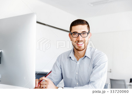 Male office worker sitting at desk 33720060