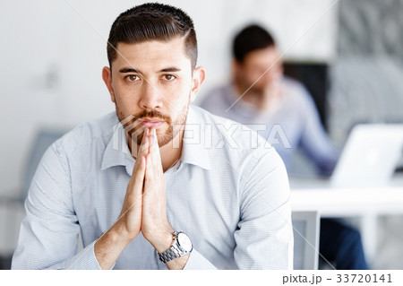 Attractive office worker sitting at desk Attractive office worker sitting at desk 33720141