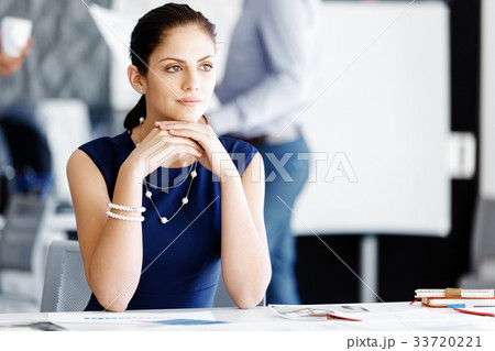 Attractive office worker sitting at desk Attractive office worker sitting at desk 33720221