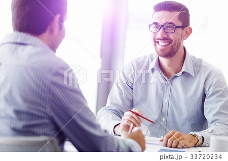 Attractive office worker sitting at desk Attractive office worker sitting at desk 33720234