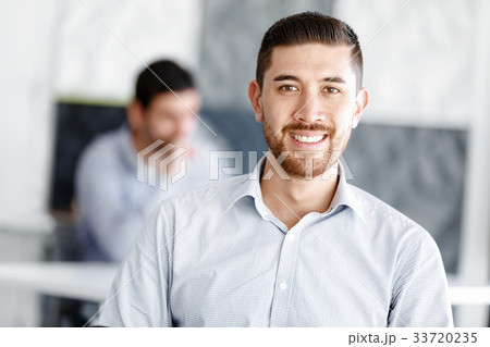 Attractive office worker sitting at desk 33720235
