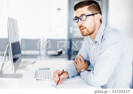 Male office worker sitting at desk 33720237