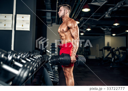 Handsome muscular man posing at a gym 33722777