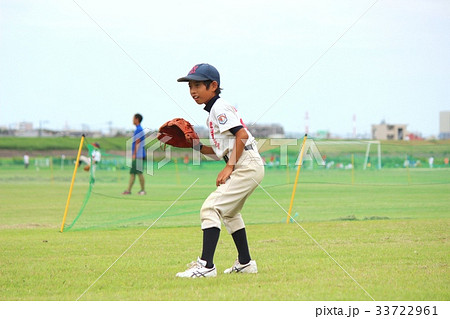笑顔でボールを待ち受けている野球少年の写真素材