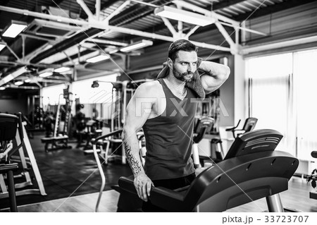 Man with a towel beside a treadmill 33723707