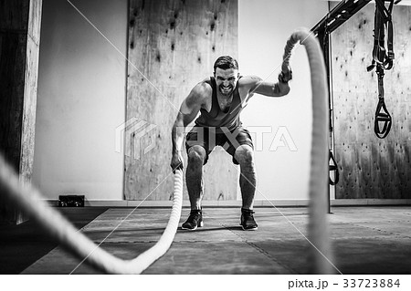 Men with rope in functional training fitness 33723884