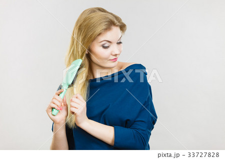 Woman brushing her long hair with brush 33727828