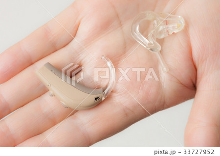 senior person holding hearing aid closeup senior person holding hearing aid closeup 33727952
