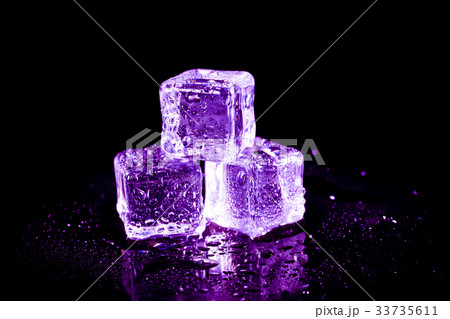 Purple ice cubes on a black table. 33735611