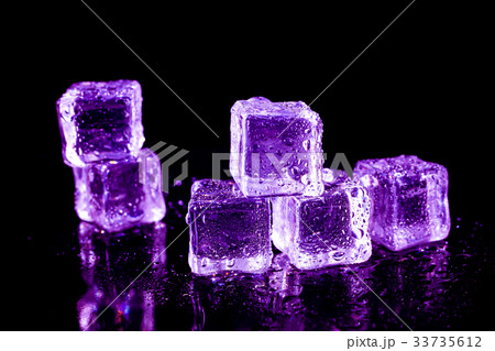 Purple ice cubes on a black table. 33735612