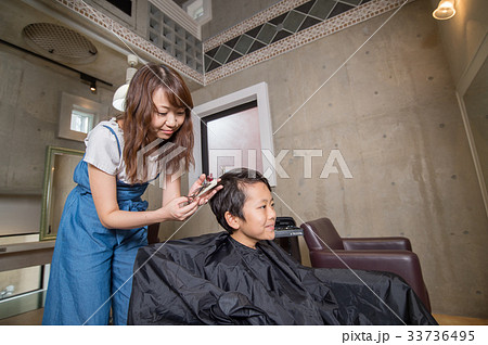 ヘアーサロン 子ども 散髪 美容院 小学生 笑顔 かわいい 理容師 カット カットモデル キッズの写真素材