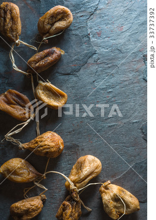 Dried beige figs with rope on a gray stone on the 33737392