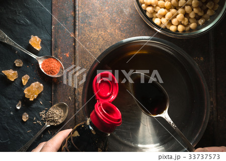 Soy sauce is poured into a spoon over a 33737573