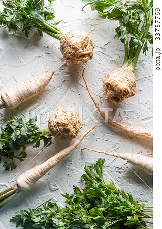 Celery roots and parsley with leaves on a white 33737769