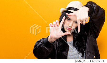 Young woman framing her face with her fingers Young woman framing her face with her fingers 33739721