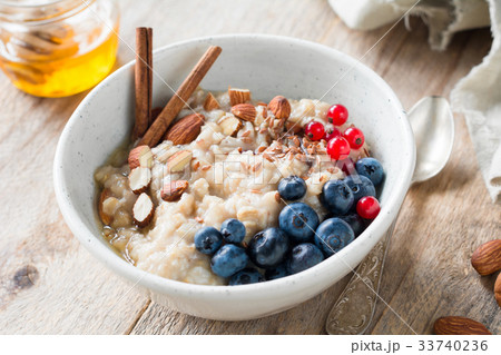 Oatmeal porridge with honey, berries and seeds in 33740236