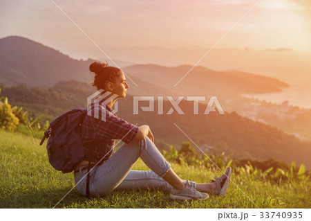 Hipster young girl with backpack enjoying sunset  33740935