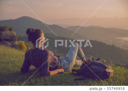 Hipster young girl with backpack enjoying sunset  33740958