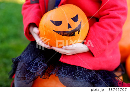 Adorable little girl wearing halloween costume having fun on a pumpkin patch Adorable little girl wearing halloween costume having fun on a pumpkin patch 33745707