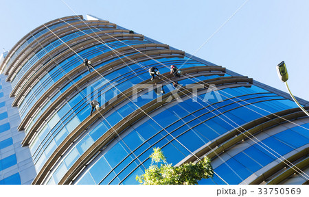 Industrial alpinists cleaning skyscraper Industrial alpinists cleaning skyscraper 33750569