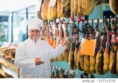 Elderly man selling tasty Spanish jamon in store 33751379