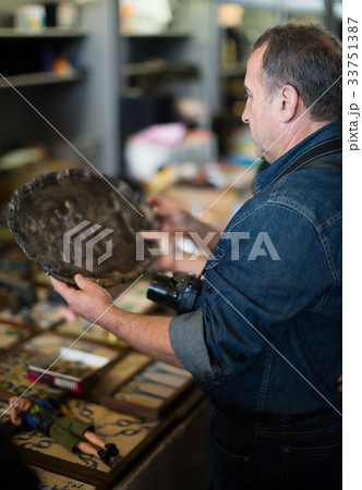 Adult tourists study the range of flea market 33751387