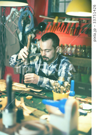 Male worker working on leather for belt in leather 33751426