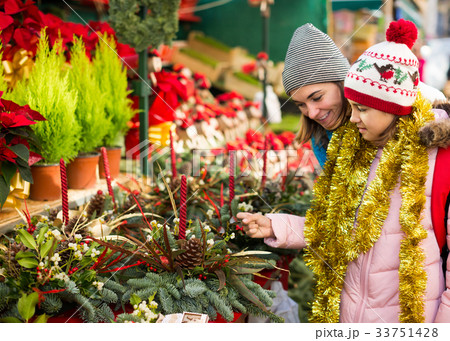 Glad mom with girl looking at flowers decoration 33751428